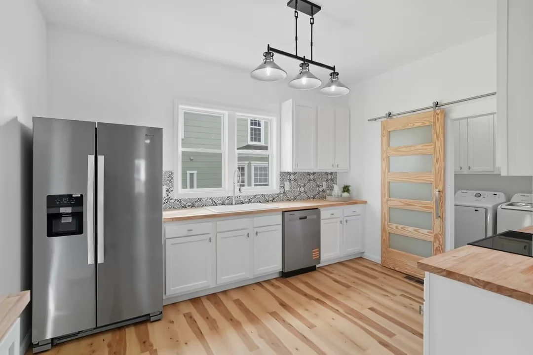 White cabinetry, wood countertops and patterned backsplash