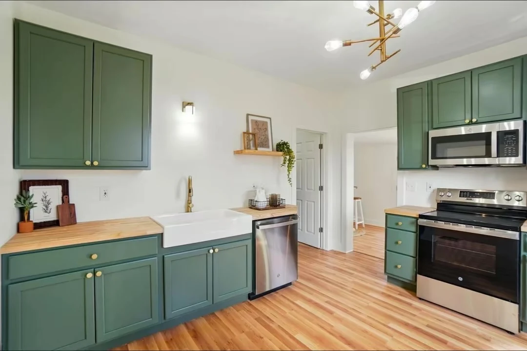 Green cabinets, farmhouse sink and stainless steel range