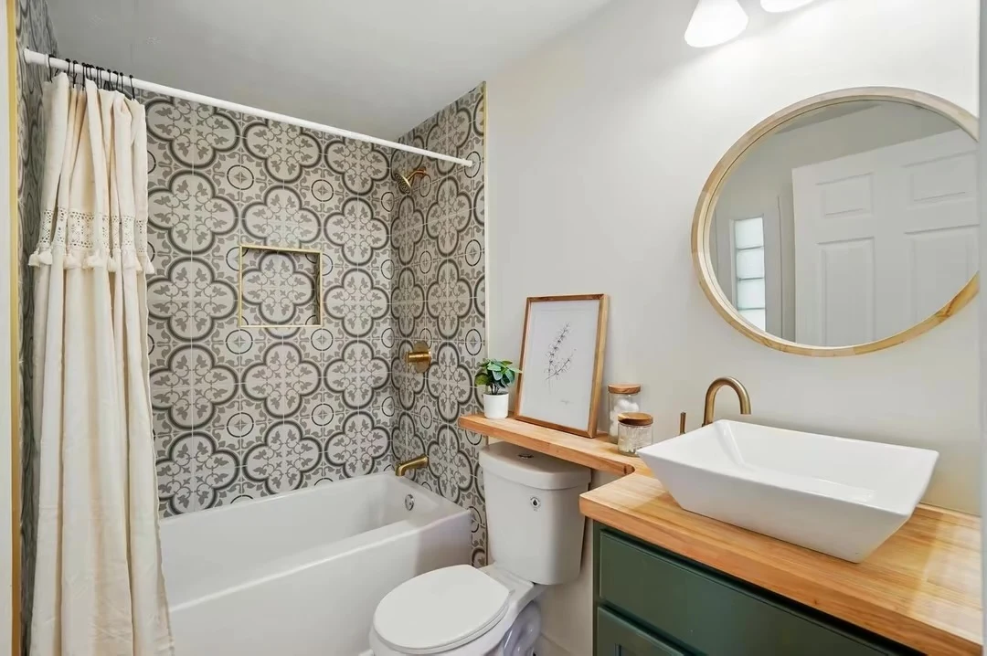 Patterned tub surround, green vanity and vessel sink