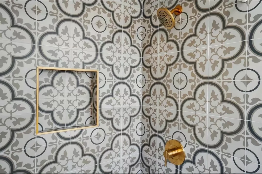 Patterned shower tile with recessed niche and brass fixtures